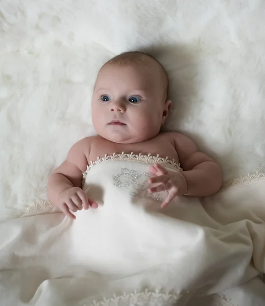 The surprised baby lying on white towel — Stock Photo, Image