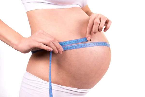 Pregnant woman measuring her belly — Stock Photo, Image