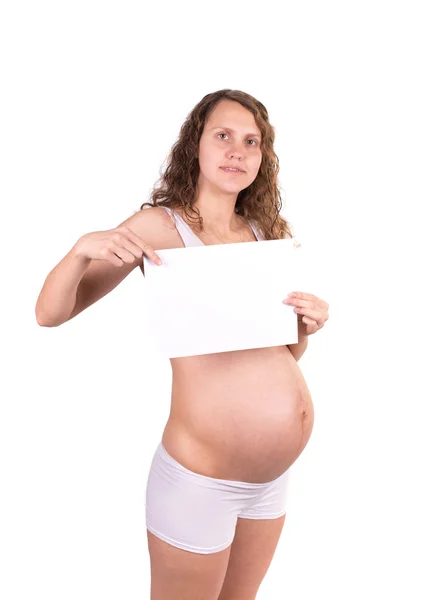 Heureuse belle femme enceinte tenant papier blanc vide isolé sur blanc — Photo