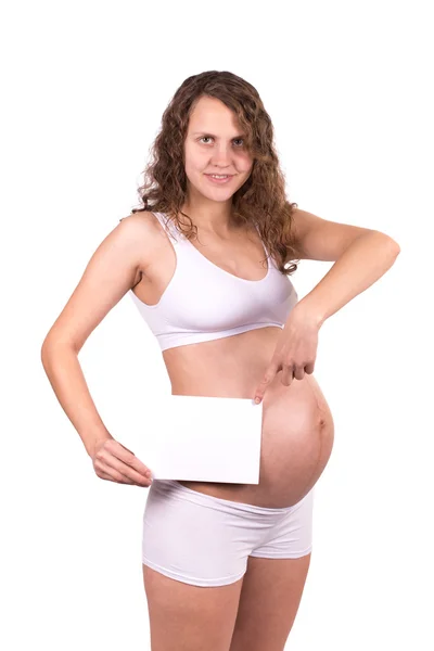 Ευτυχής όμορφη έγκυο γυναίκα, κρατώντας την κενή Λευκή Βίβλο που απομονώνονται σε λευκό — Φωτογραφία Αρχείου