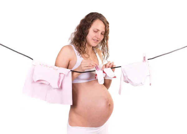 Hamile kadın üzerinde beyaz izole bebek giysileri ile zarar — Stok fotoğraf