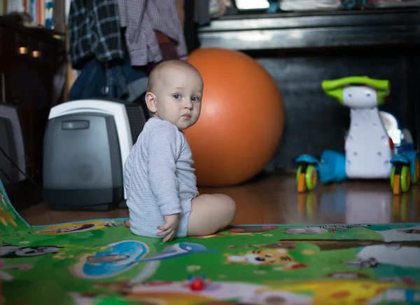 Sweet baby girl sitting and watching over her shoulder — Stock Photo, Image