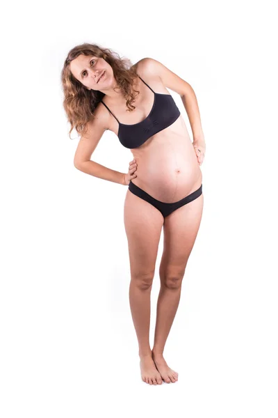 Улыбающаяся беременная женщина делает упражнения на растяжку Лицензионные Стоковые Фото