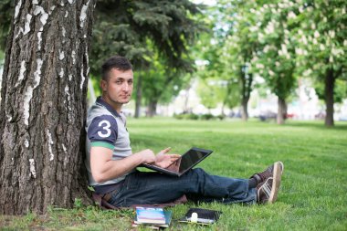 adam Park, bir ağacın altında oturup kitap okumak. açık havada okuma rahatlatıcı.