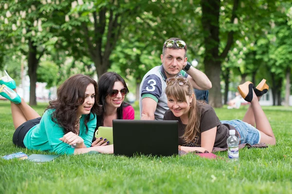 Groep tiener studenten bij park met computer en boeken — Stockfoto