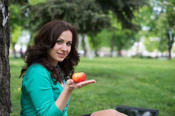Woman eating an apple outdoors — Stock Photo, Image