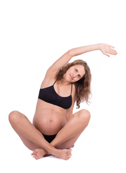 Pre-natal exercises. Beautiful pregnant woman exercising, isolated on white background — Stock Photo, Image
