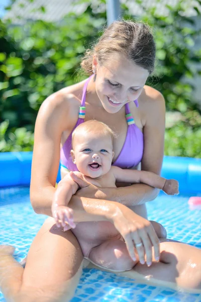 Schöne junge brünette Frau mit ihrem 6 Monate alten Baby entspannen — Stockfoto