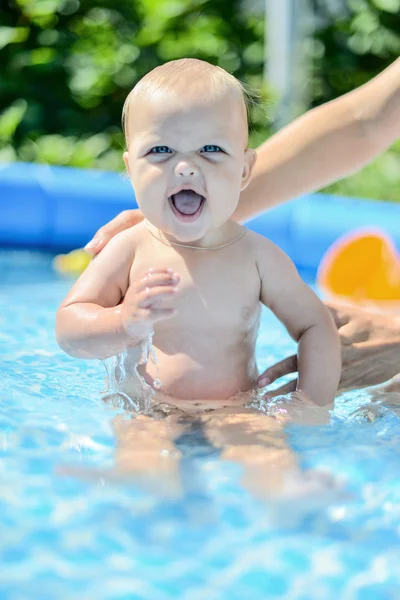 Un niño pequeño y feliz está jugando afuera en una piscina de bebé o Fotos De Stock Sin Royalties Gratis