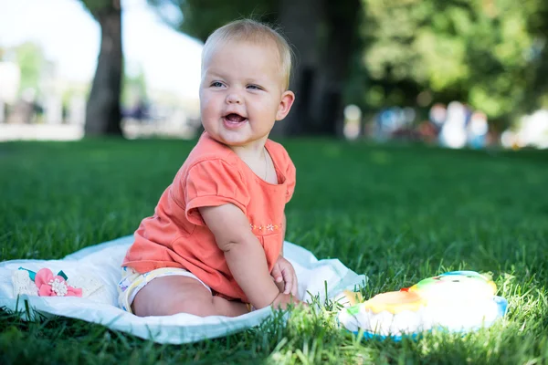 Portret letnim dzieckiem piękne dziewczyna siedzi w trawie — Zdjęcie stockowe