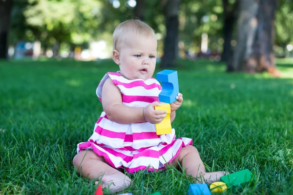 Bambino bambino ragazza che gioca cubi di legno in verde — Foto Stock