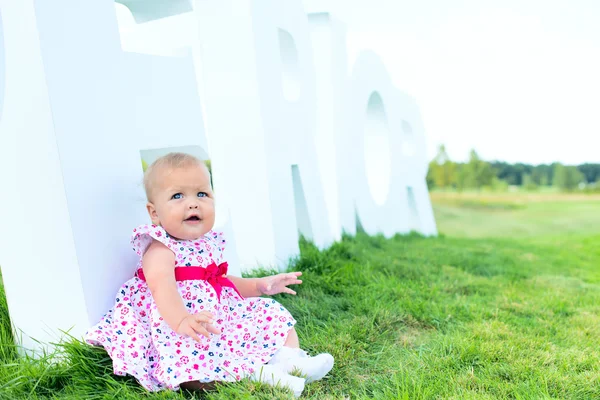 Feliz miúdo adorável no chão da relva com a carta. Amor infantil — Fotografia de Stock