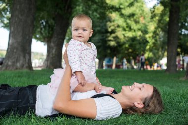 Anne ve çim parkta oynayan çocuk
