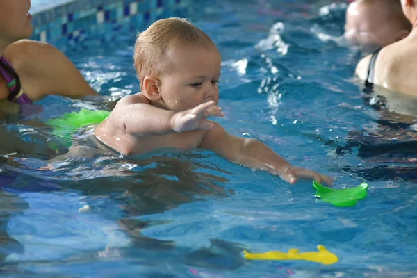 Young family with baby having fun in the swimming pool. — Stock Photo, Image