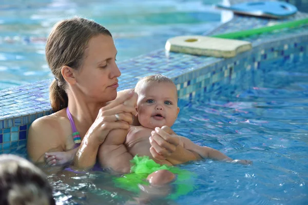 Familia joven con bebé divirtiéndose en la piscina . — Foto de Stock