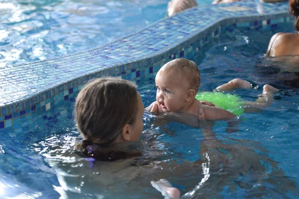 Familia joven con bebé divirtiéndose en la piscina . — Foto de Stock