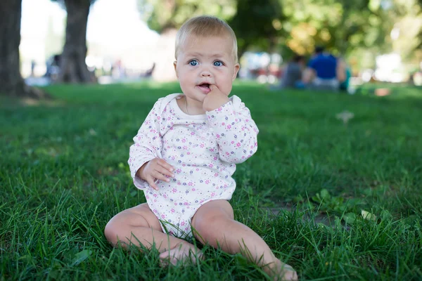 Leuke speelse geglimlacht blond 0.8 jaar oude meisjes zitten op groene g — Stockfoto