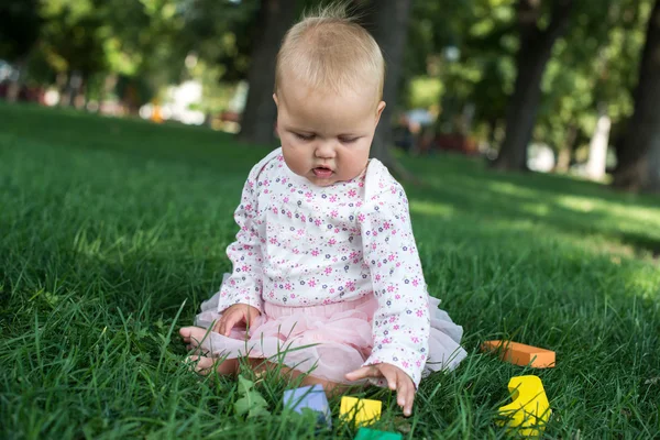 Lindo juguetón sonrió rubio 0.8 años niñas sentadas en verde g — Foto de Stock