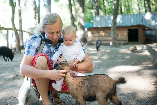 Portret szczęśliwy ojciec i jego córeczka karmienia papuga — Zdjęcie stockowe