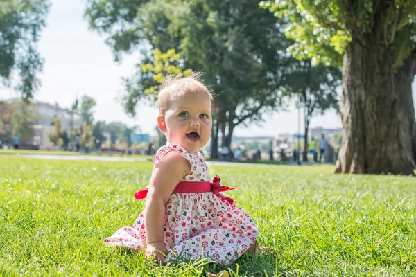 Fille ludique assis sur une prairie. Bébé mignon . — Photo