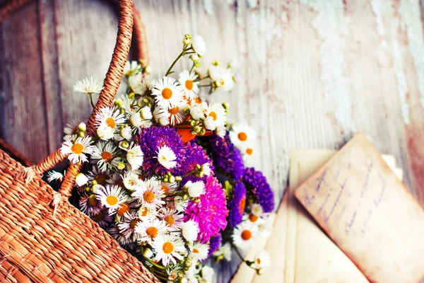 Flores en la cesta con letras viejas — Foto de Stock