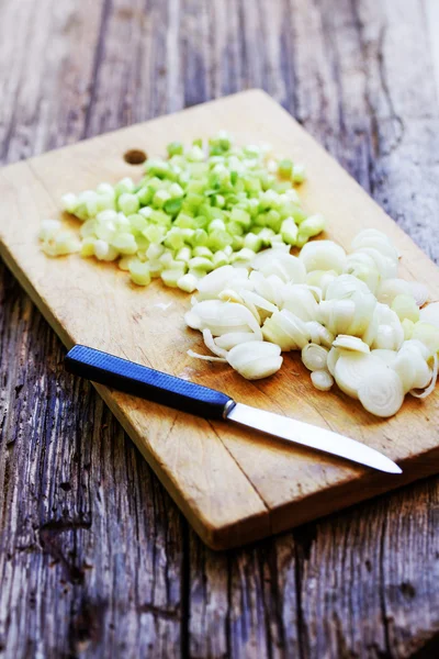 Cutting Onion on a wooden board — Stock Photo, Image