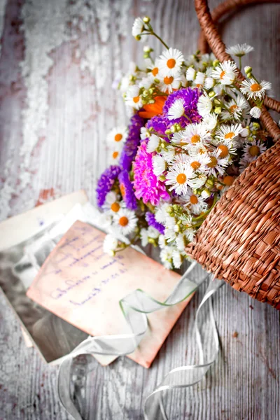 Flores en la cesta con letras viejas — Foto de Stock