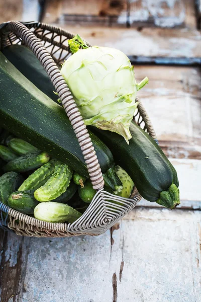 Zucchini, cabbage and cucumbers on wooden table