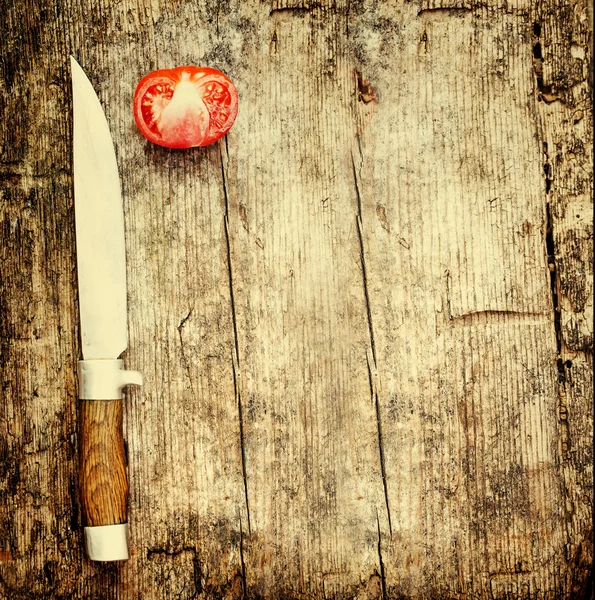 Knife and tomato on wooden table — Stock Photo, Image