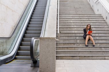 Merdivenlerden scalator tablet ile yanında çalışan kadın ofis