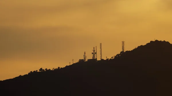 通信塔を持つ山に沈む夕日 — ストック写真