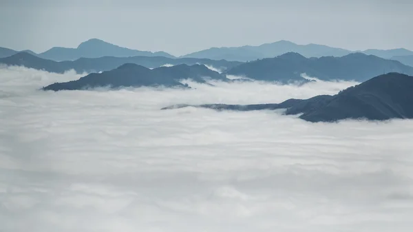 Over de wolken en mist tussen bergtoppen landschap — Stockfoto