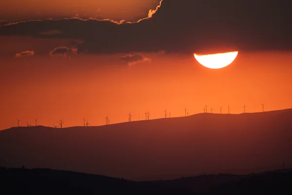 Sunset over mountains with modern windmills — Stock Photo, Image