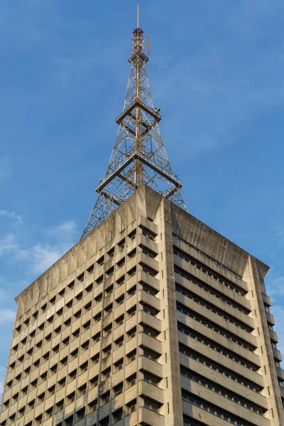 Edifício antigo com torre de comunicação — Fotografia de Stock