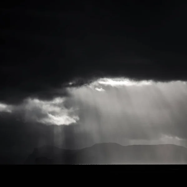 Nuvole scure sull'isola e sull'oceano con raggi luminosi — Foto Stock