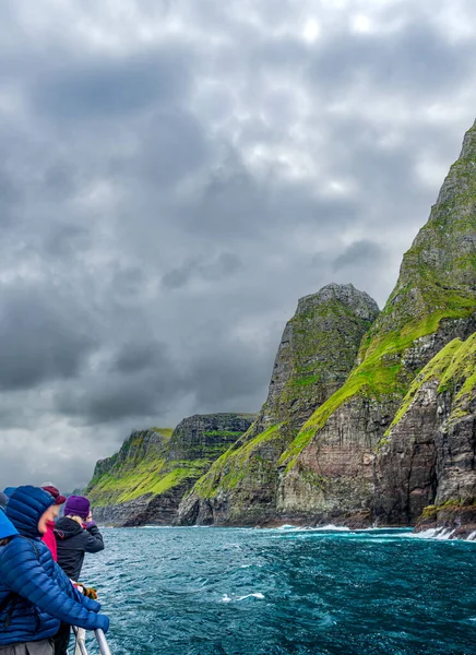 Wazig onherkenbare toeristen over boot observeren indrukwekkende Vestmanna kliffen — Stockfoto