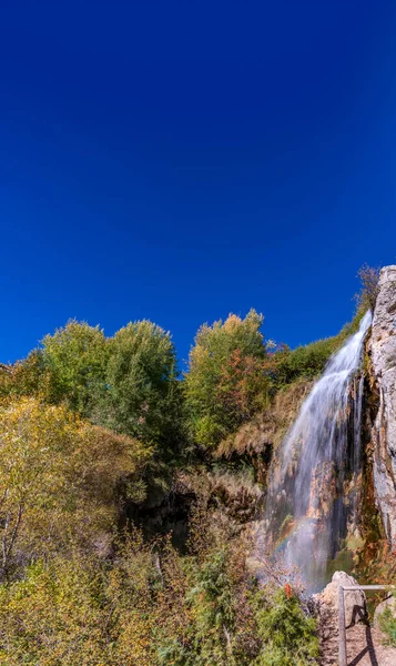 Waterval bij de bron van de rivier Jucar, verticale samenstelling met blauwe lucht — Stockfoto