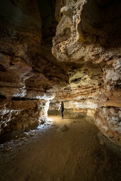 Nierozpoznawalna osoba wchodząca do jaskini ze światłem — Zdjęcie stockowe