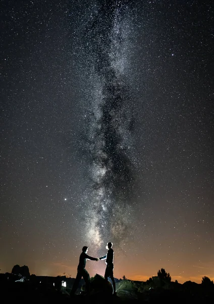 Duas pessoas apertando as mãos contra a forma leitosa — Fotografia de Stock