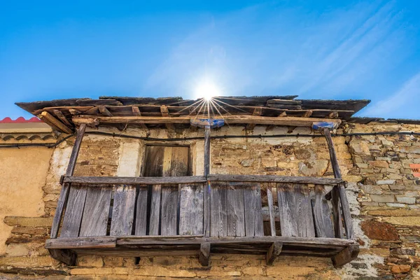 Antiguo balcón de madera vintage bajo sol estrellado y cielo azul — Foto de Stock