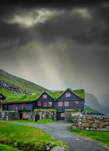 Typische Noordse huizen onder stralingslicht vanuit de wolken — Stockfoto