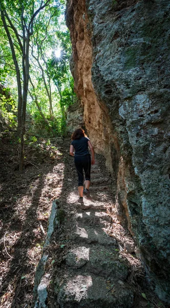 Visão traseira da mulher irreconhecível caminhadas perto das rochas — Fotografia de Stock