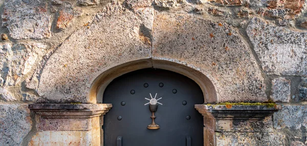 Eiserner Kelch über der Eisentür, Steinbogenfassade — Stockfoto