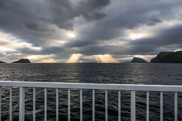 Matahari terbenam gelap dengan sinar lampu dari rel kapal besar — Stok Foto