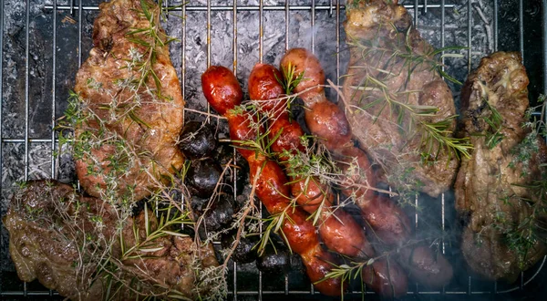 Bovenaanzicht op de barbecue met vlees, worst en rozemarijn — Stockfoto