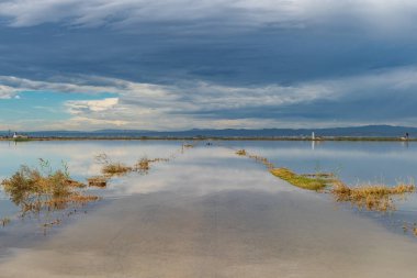 Fırtınadan sonra bulutlu gökyüzünün altında sel basmış yol