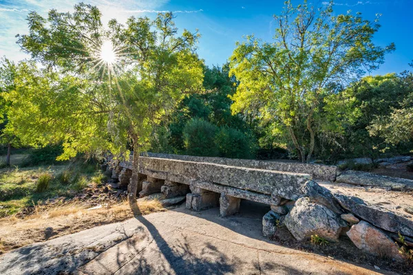 Antieke stenen brug over de droge rivier met zonnester — Stockfoto