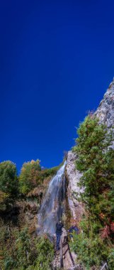 Mavi gökyüzü altında turistlerle şelaleye uzun süre maruz kalmak