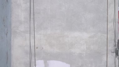 Boya rulosu ve iskelesi olan bir duvar.