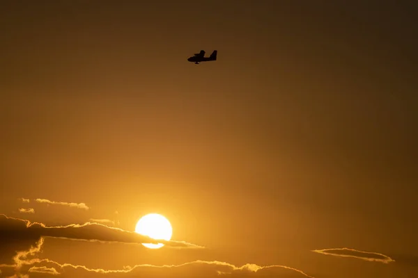 Silueta hidroplana al atardecer con cielo naranja —  Fotos de Stock